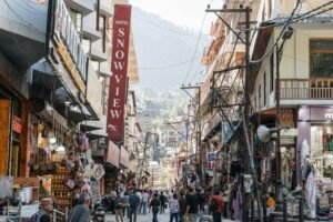 The Modern Travel Agency: Your Secret Weapon for 2026 Vibrant street market in Manali, India showcasing local shops and bustling crowds under clear skies.